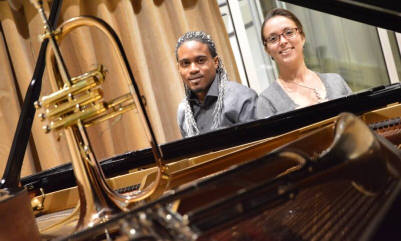 deux personnes qui posent pour une photographie devant des instruments